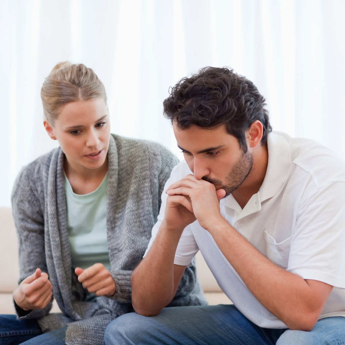 A couple sitting and talking on a couch