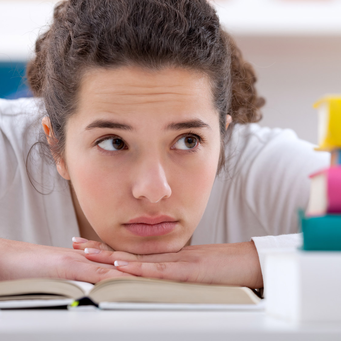 Teen girl with her head on her desk at school